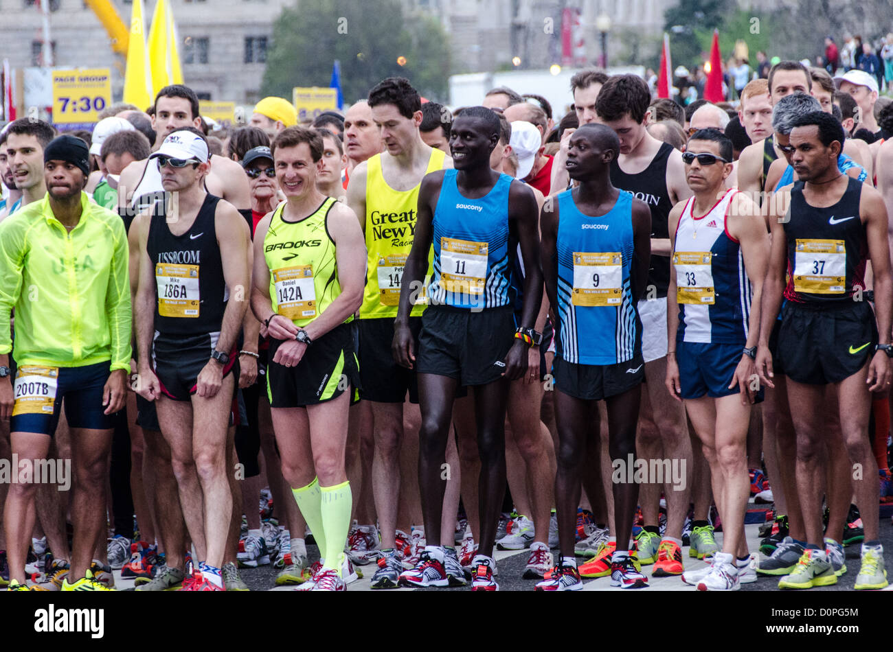 WASHINGTON DC – die Elite-Läufer der Männer nur wenige Minuten vor dem Start der Cherry Blossom 10-Miler 2012. Rechts, in der Startnummer 9, steht der spätere Sieger Allan Kiprono aus Kenia, der einen neuen Streckenrekord von 45:15 aufstellte. Zu seiner Rechten, in Nummer 11, befindet sich Lani Kiplagat, ebenfalls aus Kenia, der in 46:28. In diesem Jahr fand das 40. Rennen statt, das jedes Frühjahr in Washington D.C. stattfindet und mit dem National Cherry Blossom Festival zusammenfällt. Der Kurs beginnt in der Nähe des Washington Monuments, führt über die Memorial Bridge und zurück, führt hinauf unter dem Kennedy Center, um das Tidal Basin und p Stockfoto