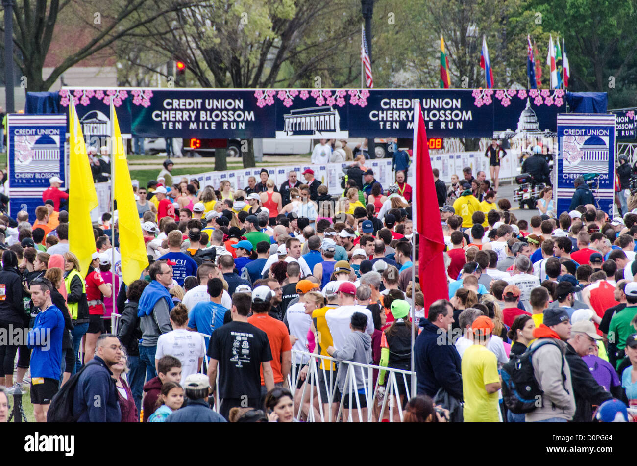 Der Kundenansturm der Läufer an der Startlinie zum Jahresbeginn 2012 Cherry Blossom 10-Miler, 40. Ablauf des Rennens, die jeden Frühling in Washington, D.C. zusammen mit der National Cherry Blossom Festival ausgeführt wird. Der Kurs beginnt in der Nähe des Washington Monument, Köpfe über Memorial Bridge und zurück, steigt unter dem Kennedy Center, um das Tidal Basin und vorbei an dem Jefferson Memorial und führt dann eine Schleife um Hains Point zurück ins Ziel in der Nähe des Washington Monument. Stockfoto