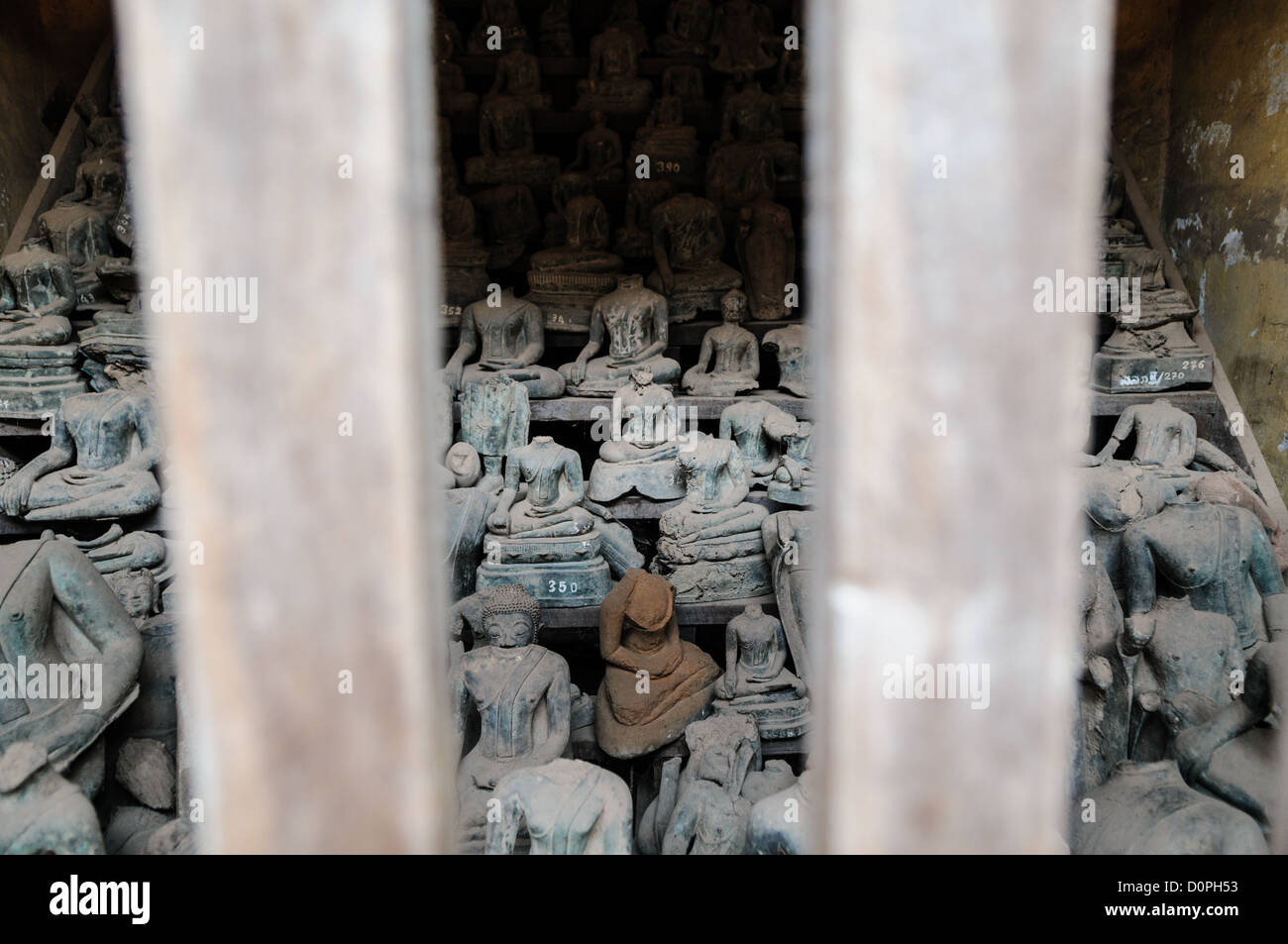 Wat Sisaket gebrochene Buddha-Statuen Vientiane Laos // VIENTIANE, Laos — gebrochene Keramik-Buddha-Statuen, die während des Krieges beschädigt wurden, werden in einem Raum im Wat Sisaket-Tempel in Vientiane ausgestellt. Laut Schildern an der Stätte wurden diese Fragmente bei Ausgrabungen in Vientiane entdeckt und aus der Hauptsammlung des Tempels mit etwa 2.000 Keramik- und Silber-Buddha-Statuen im Kreuzgang entfernt. Das 1818 erbaute Wat Sisaket wurde im siamesischen Architekturstil statt im traditionellen laotischen Design erbaut. Der Tempel gilt weithin als einer der ältesten erhaltenen Stockfoto