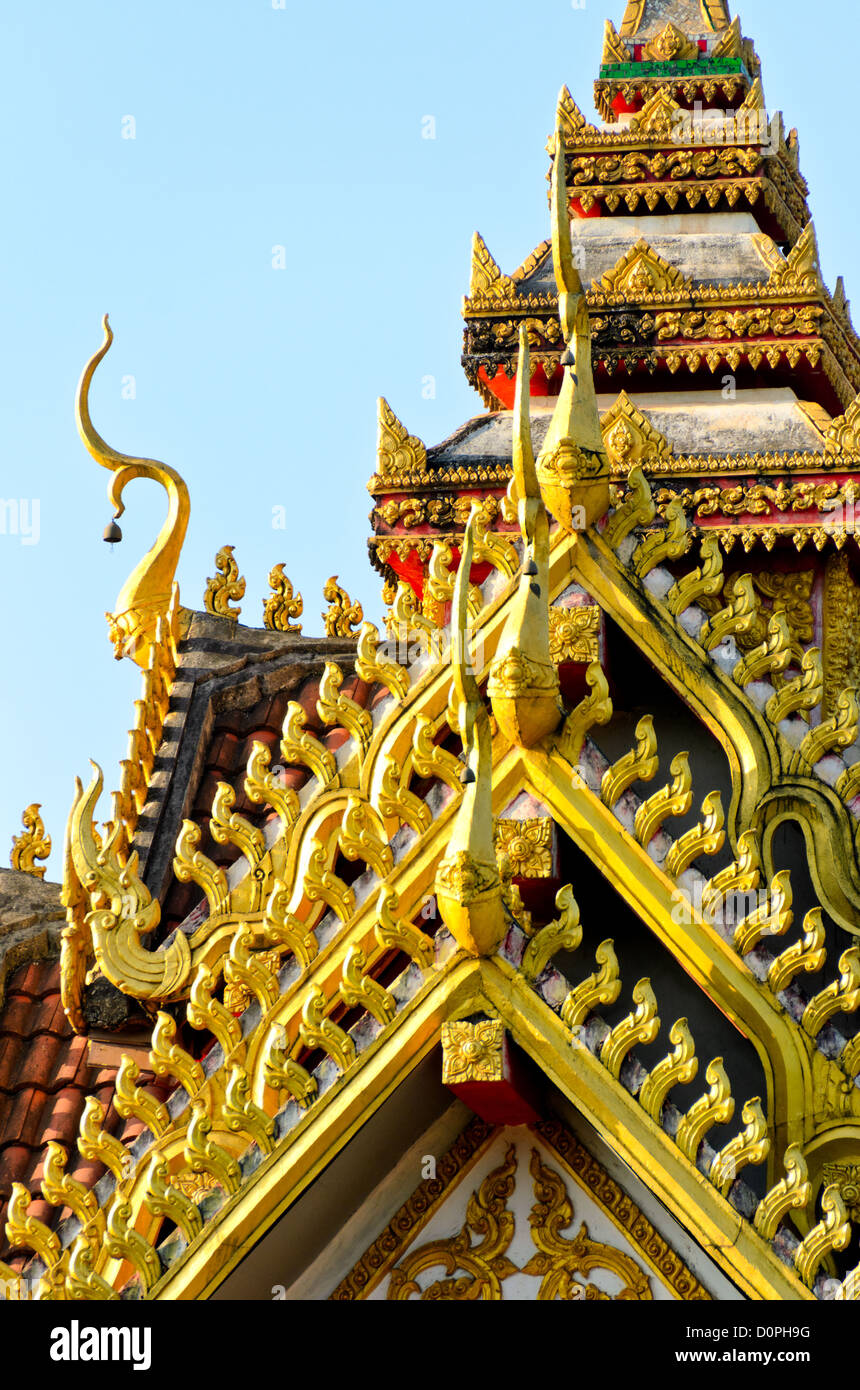Wat Sisaket Roof Vientiane Laos // VIENTIANE, Laos — Teil des verzierten fünfstöckigen Dachs im Wat Sisaket in Vientiane zeigt den unverwechselbaren siamesischen Architekturstil des Tempels. Der Tempel wurde 1818 während der Regierungszeit von König Anouvong erbaut und war eher im siamesischen Stil als in der traditionellen laotischen Architektur erbaut, was die politischen und kulturellen Einflüsse dieser Zeit widerspiegelt. Der Wat Sisaket gilt weithin als der älteste noch existierende Tempel in Vientiane, nachdem er die siamesische Invasion von 1828 überlebt hat, die einen Großteil der Stadt zerstörte. Der Tempel ist bekannt für seine Tausenden von Buddha-Bildern in n Stockfoto