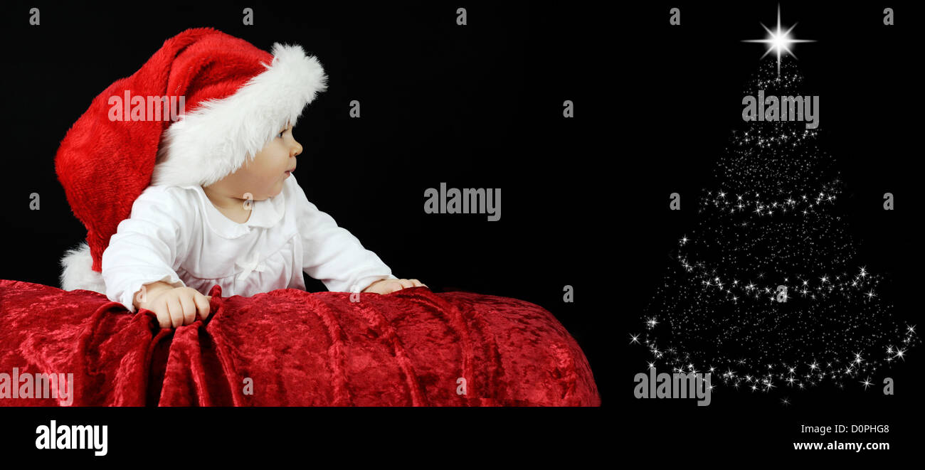 Baby mit Weihnachtsmütze, liegend auf dem Bauch Stockfoto