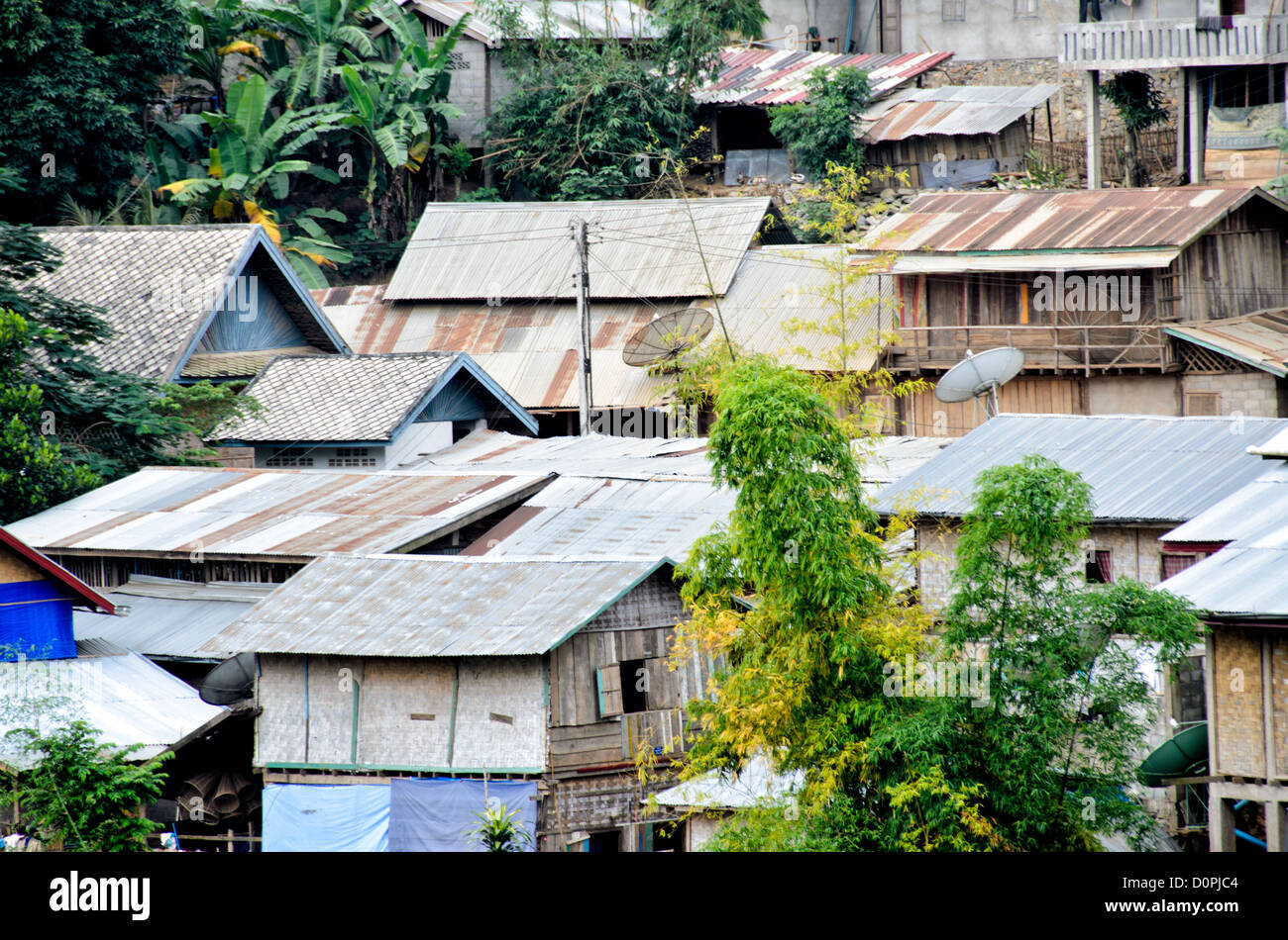 Nong Khiaw Village Waterfront Houses Laos // NONG KHIAW, Laos — Häuser säumen die Uferpromenade im Dorf Nong Khiaw im Norden Laos. Die Siedlung liegt am Fluss Nam Ou in der Provinz Luang Prabang, zwischen dramatischen Kalksteinkarstbergen. Nong Khiaw dient als Tor zum ländlichen Norden von Laos und wird häufig als Basis für die Erkundung des umliegenden bergigen Geländes genutzt. Das Dorf hat sich als Haltepunkt entlang der Nam ou River Route entwickelt, die Luang Prabang mit der chinesischen Grenze verbindet. Das Gebiet ist Teil der größeren nördlichen Region Laos, die für ihre traditionelle laotische Landschaft bekannt ist Stockfoto