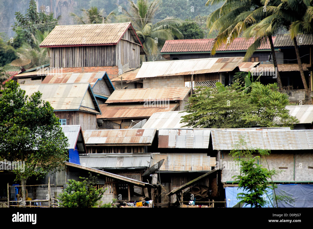 Nong Khiaw Village Waterfront Laos // NONG KHIAW, Laos — Häuser säumen die Uferpromenade im Dorf Nong Khiaw im Norden Laos. Die Siedlung liegt am Fluss Nam Ou in der Provinz Luang Prabang, zwischen dramatischen Kalksteinkarstbergen. Nong Khiaw dient als Tor zum ländlichen Norden von Laos und wird häufig als Basis für die Erkundung des umliegenden bergigen Geländes genutzt. Das Dorf hat sich als Haltepunkt entlang der Nam ou River Route entwickelt, die Luang Prabang mit der chinesischen Grenze verbindet. Das Gebiet ist Teil der größeren nördlichen Region Laos, die für ihre traditionelle laotische Landstraße bekannt ist Stockfoto
