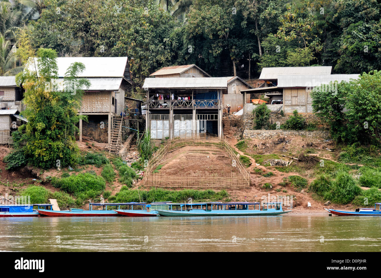 Nong Khiaw Village Waterfront Nam ou River Laos // NONG KHIAW, Laos — Häuser säumen die Uferpromenade im Dorf Nong Khiaw im Norden Laos. Die Siedlung liegt am Fluss Nam Ou in der Provinz Luang Prabang, zwischen dramatischen Kalksteinkarstbergen. Nong Khiaw dient als Tor zum ländlichen Norden von Laos und wird häufig als Basis für die Erkundung des umliegenden bergigen Geländes genutzt. Das Dorf hat sich als Haltepunkt entlang der Nam ou River Route entwickelt, die Luang Prabang mit der chinesischen Grenze verbindet. Das Gebiet ist Teil der größeren nördlichen Region Laos, die für ihr traditionelles Laos bekannt ist Stockfoto Nong Khiaw Village Waterfront Nam ou River Laos // NONG KHIAW, Laos — Häuser säumen die Uferpromenade im Dorf Nong Khiaw im Norden Laos. Die Siedlung liegt am Fluss Nam Ou in der Provinz Luang Prabang, zwischen dramatischen Kalksteinkarstbergen. Nong Khiaw dient als Tor zum ländlichen Norden von Laos und wird häufig als Basis für die Erkundung des umliegenden bergigen Geländes genutzt. Das Dorf hat sich als Haltepunkt entlang der Nam ou River Route entwickelt, die Luang Prabang mit der chinesischen Grenze verbindet. Das Gebiet ist Teil der größeren nördlichen Region Laos, die für ihr traditionelles Laos bekannt ist Stockfoto