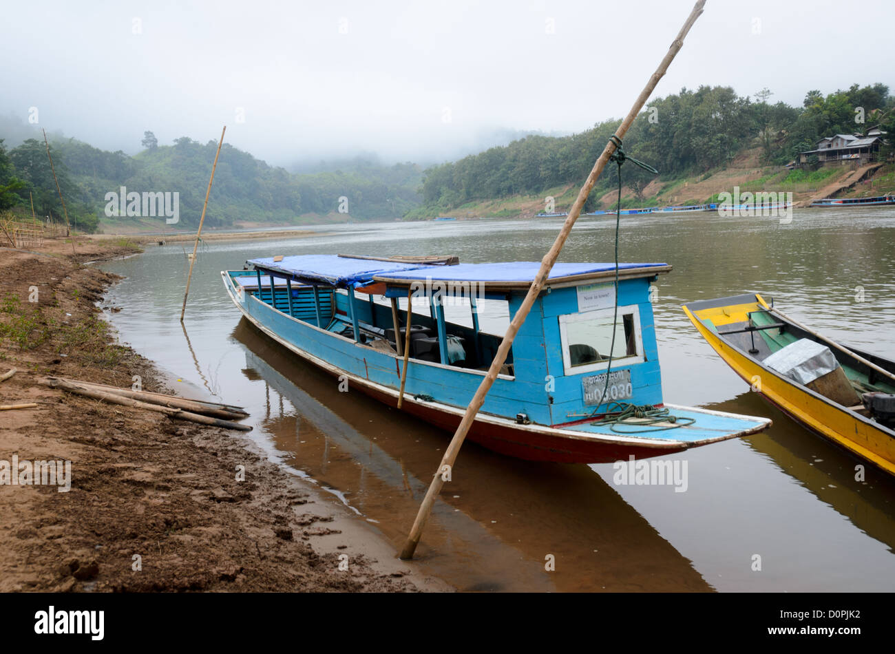 NONG KHIAW, Laos - Schnelle Passagierschiffe gegen das Ufer des Flusses Nam Ou (Organisationseinheit) in Nong Khiaw in norther Laos vertäut. Stockfoto