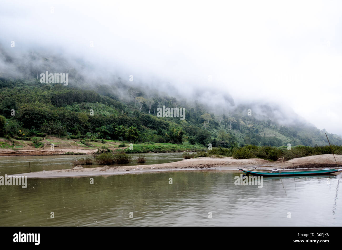 NONG KHIAW, Laos - Nebel roll Verkleidung die steilen Kalkstein Karst am Ufer des Flusses Nam Ou (Organisationseinheit) in Nong Khiaw in norther Laos. Sanbanks in der Mitte des Flusses bilden kleine Sand Inseln und geschützte Liegeplätze. Stockfoto