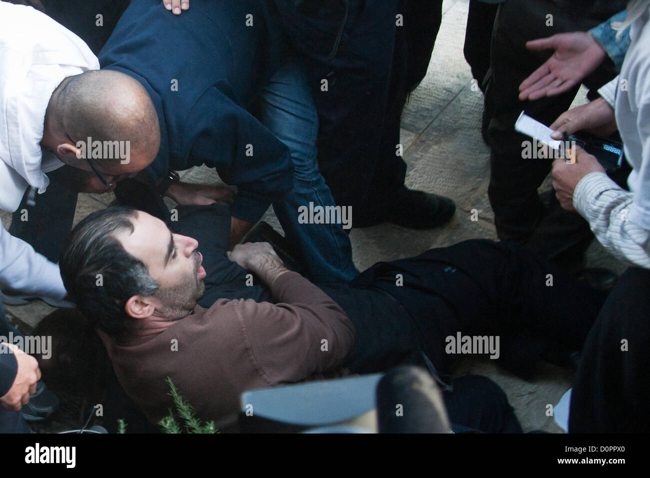 Jerusalem, Israel. 29. November 2012. Wie Polizei erfolgreich eine palästinensische Fahne aus den Händen von Demonstranten, die verhindern, dass sie brennen es reißen, läuft ein Mann in der Menge mit einer zusätzlichen Flagge. Polizei Detektive lösen ihn auf den Boden und machen eine Verhaftung. Jerusalem, Israel. 29. November 2012.  MKs Michael Ben-Ari und Aryeh Eldad, der extremen Rechten Otzma Leyisrael Partei, Blei-Aktivisten in einem palästinensischen Flagge brennenden versuchen auf UN-Gebäude in Jerusalem demonstrieren gegen palästinensische Staatlichkeit Gebot bei der UN-Generalversammlung in New York. Stockfoto