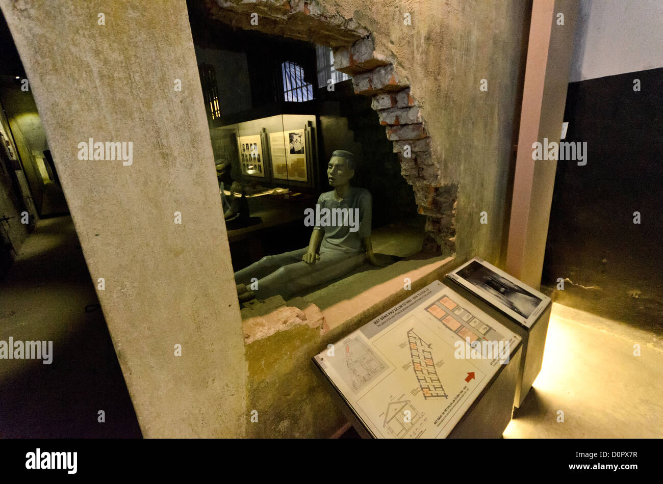 Hoa Lo Gefängnis Todeszelle Hanoi Vietnam // HANOI, Vietnam — ein Teil der ursprünglichen Mauer wurde abgeschnitten und durch Glas ersetzt, so dass Besucher in die kleinen, dunklen Zellen entlang der Todesrwo im Hoa Lo Gefängnis in Hanoi sehen können. Eine Plastikpuppe illustriert die Bedingungen. Im Westen besser bekannt als „The Hanoi Hilton“, ist ein Teil des Gefängnisses als Museum erhalten. Stockfoto