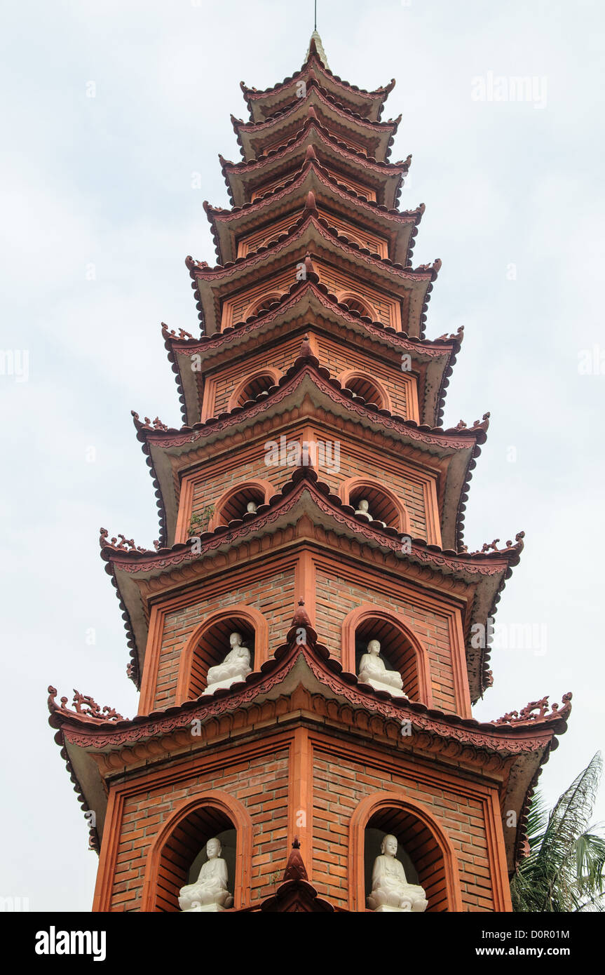 HANOI, Vietnam - ein Backstein Turm mit weißen Buddhastatuen aus Tran Quoc Pagode auf einer kleinen Insel auf dem West Lake (Ho Tay). Ursprünglich im 6. Jahrhundert gebaut an den Ufern des Roten Flusses, eine Änderung des Flusses gezwungen, die Pagode 1615 Zum Goldenen Fisch verlegt werden (Kim Ngu) Insel auf dem See. Stockfoto