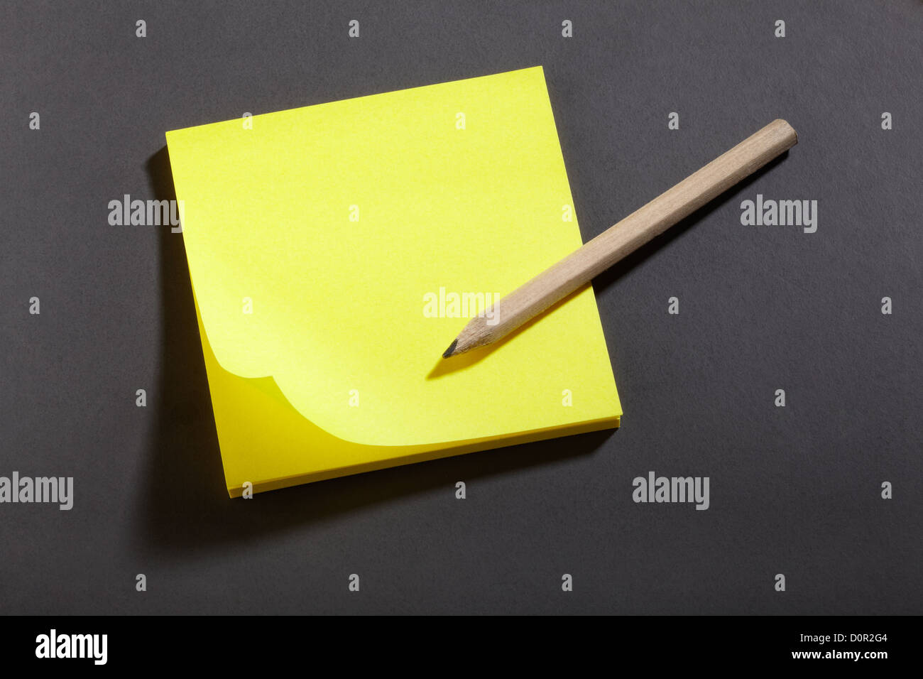 Gelber Aufkleber Hinweis und Bleistift auf Tafel Stockfoto