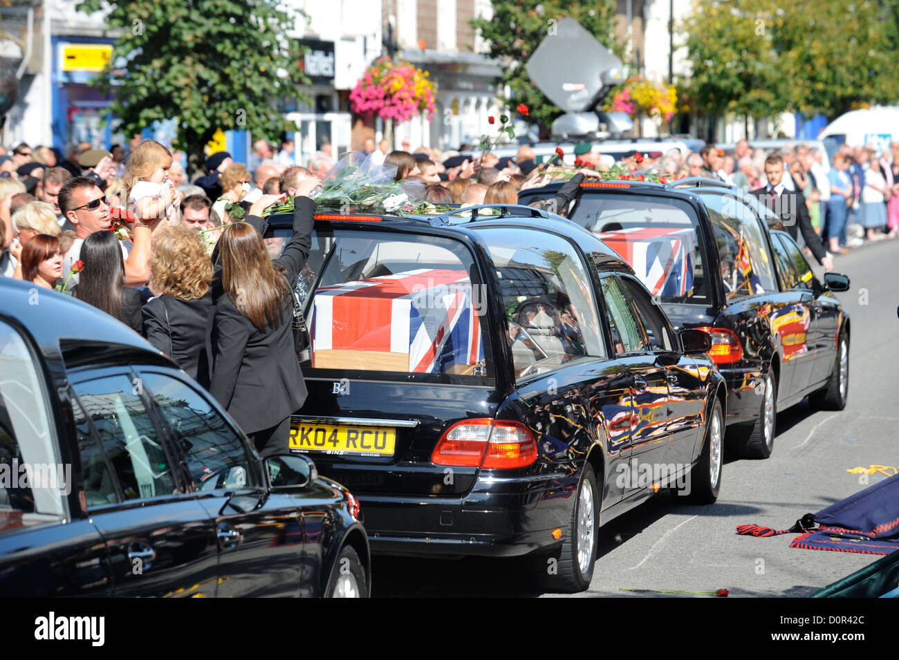 Freunde und verwandte werfen Blumen über ein Trauerzug Leichenwagen während einer Rückführung Zeremonie für britische Soldaten getötet in Afgh Stockfoto