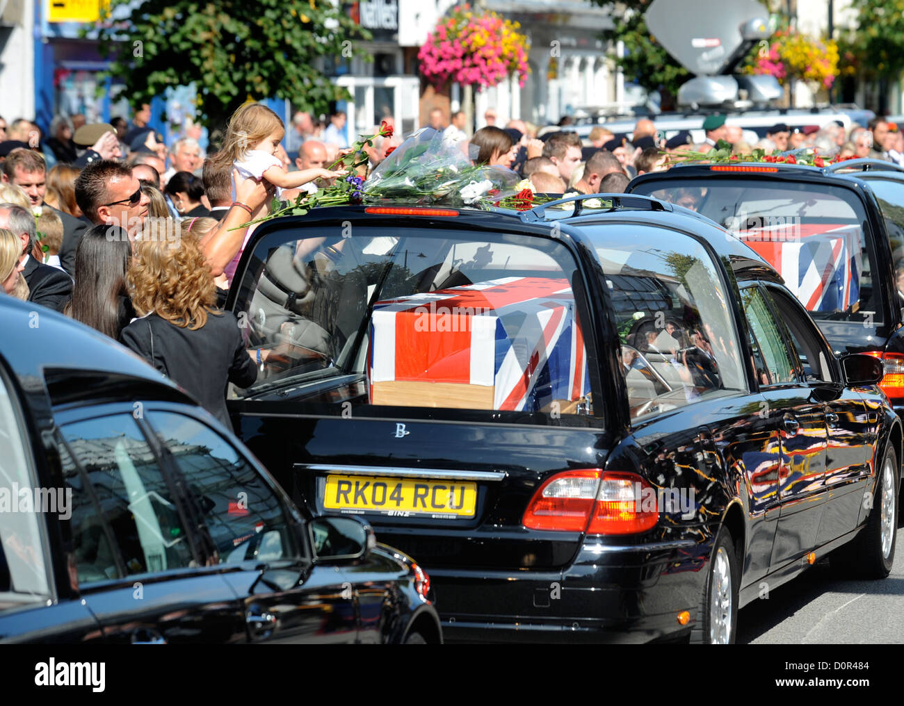 Freunde und verwandte werfen Blumen über ein Trauerzug Leichenwagen während einer Rückführung Zeremonie für britische Soldaten getötet in Afgh Stockfoto