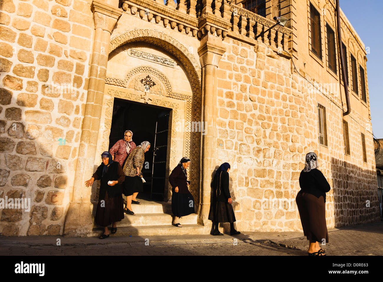 Syriac Frauen verlassen die Kirche nach der Messe. Midyat, Provinz Mardin, Türkei Stockfoto