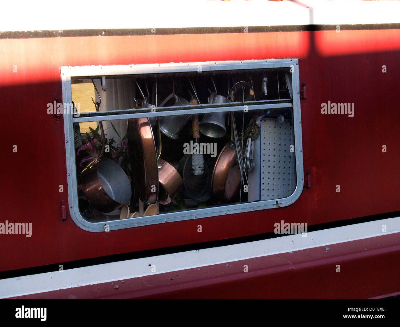 Kupfer Pfannen und Küchengeräte hängen im Fenster von einem Kanalboot, UK Stockfoto