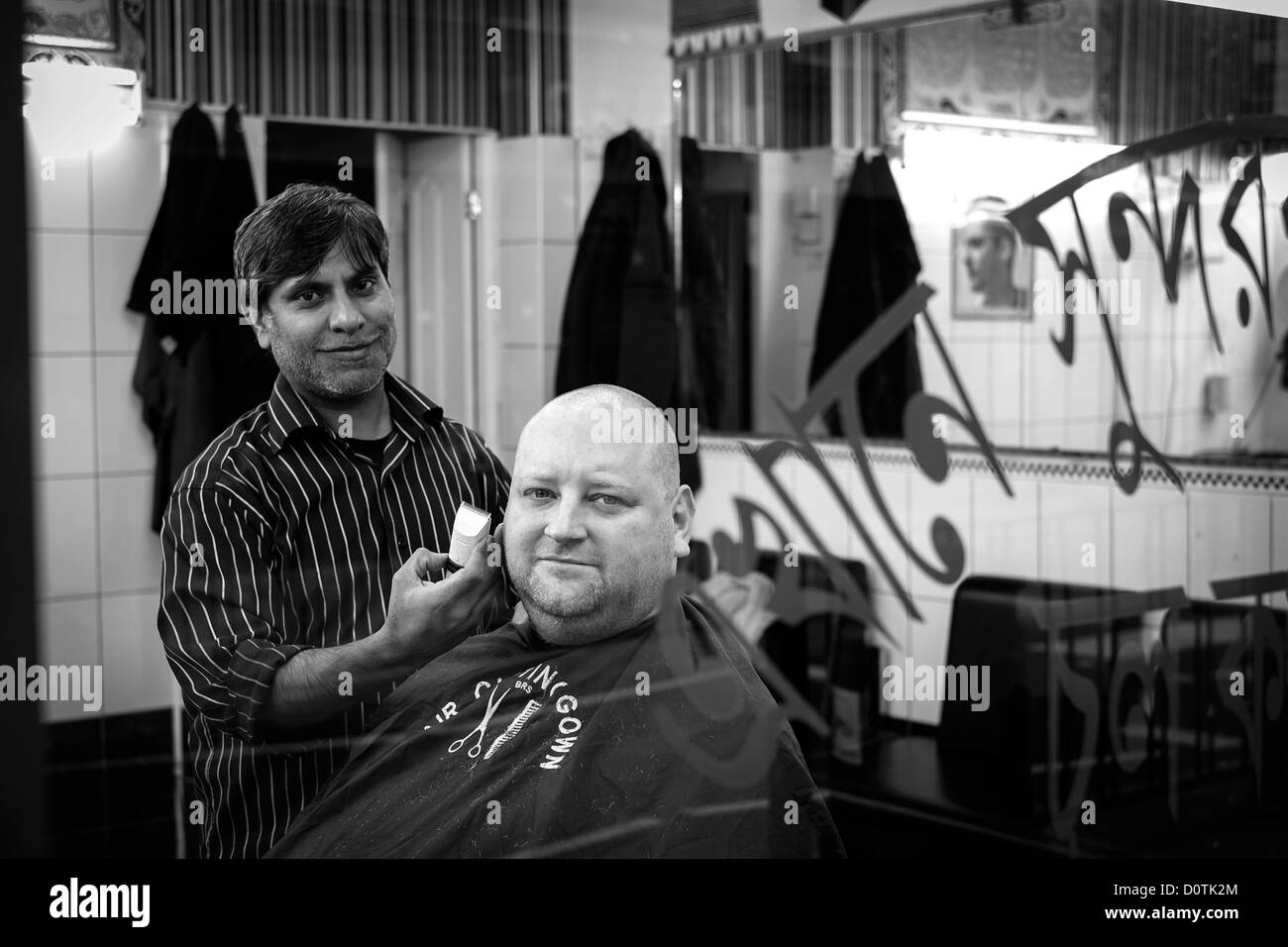 Asiatischen Friseur schneiden ein mans Haare auf Brick Lane London E1 Stockfoto