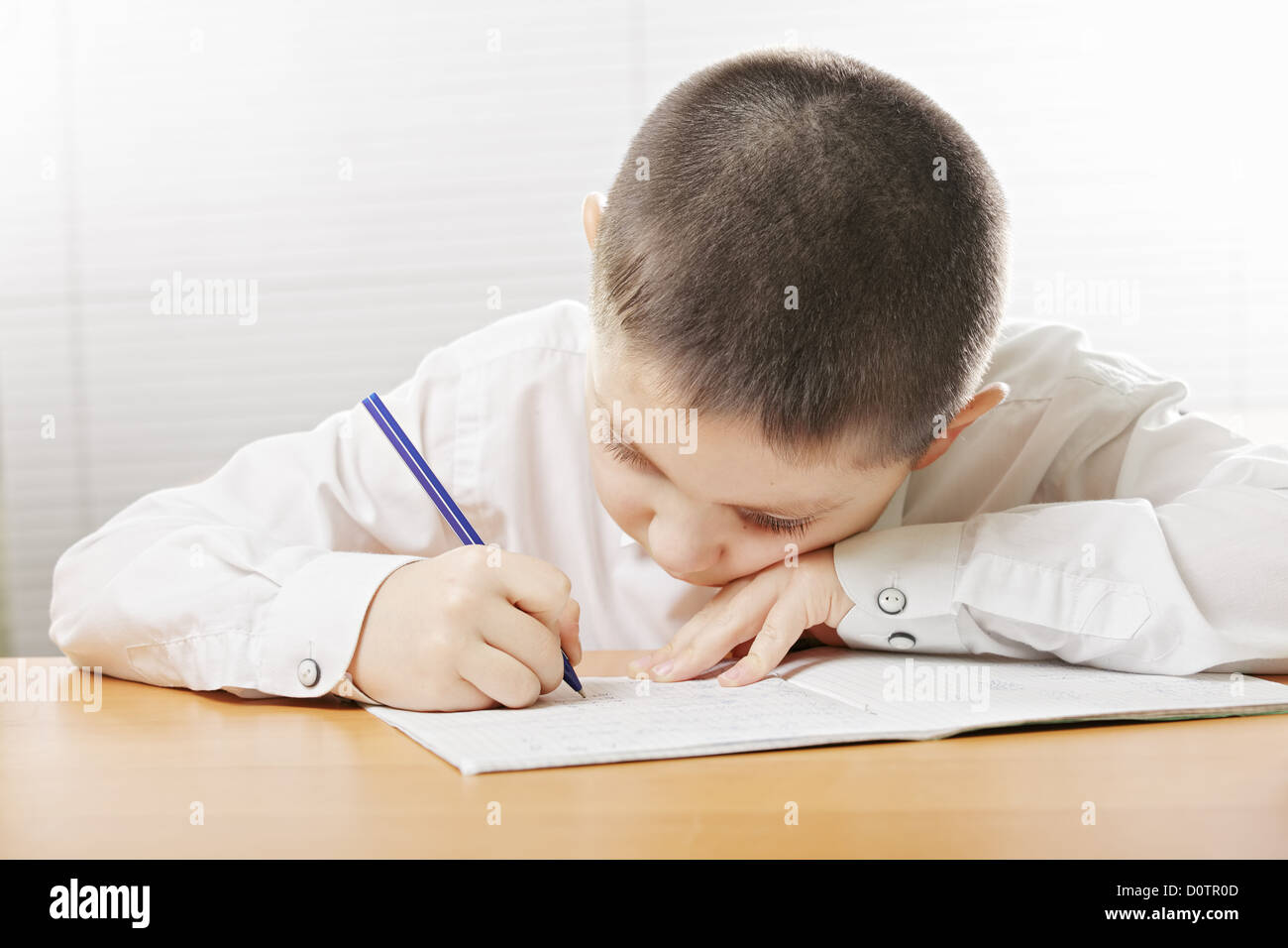 Junge schreiben Copybook bücken Stockfoto