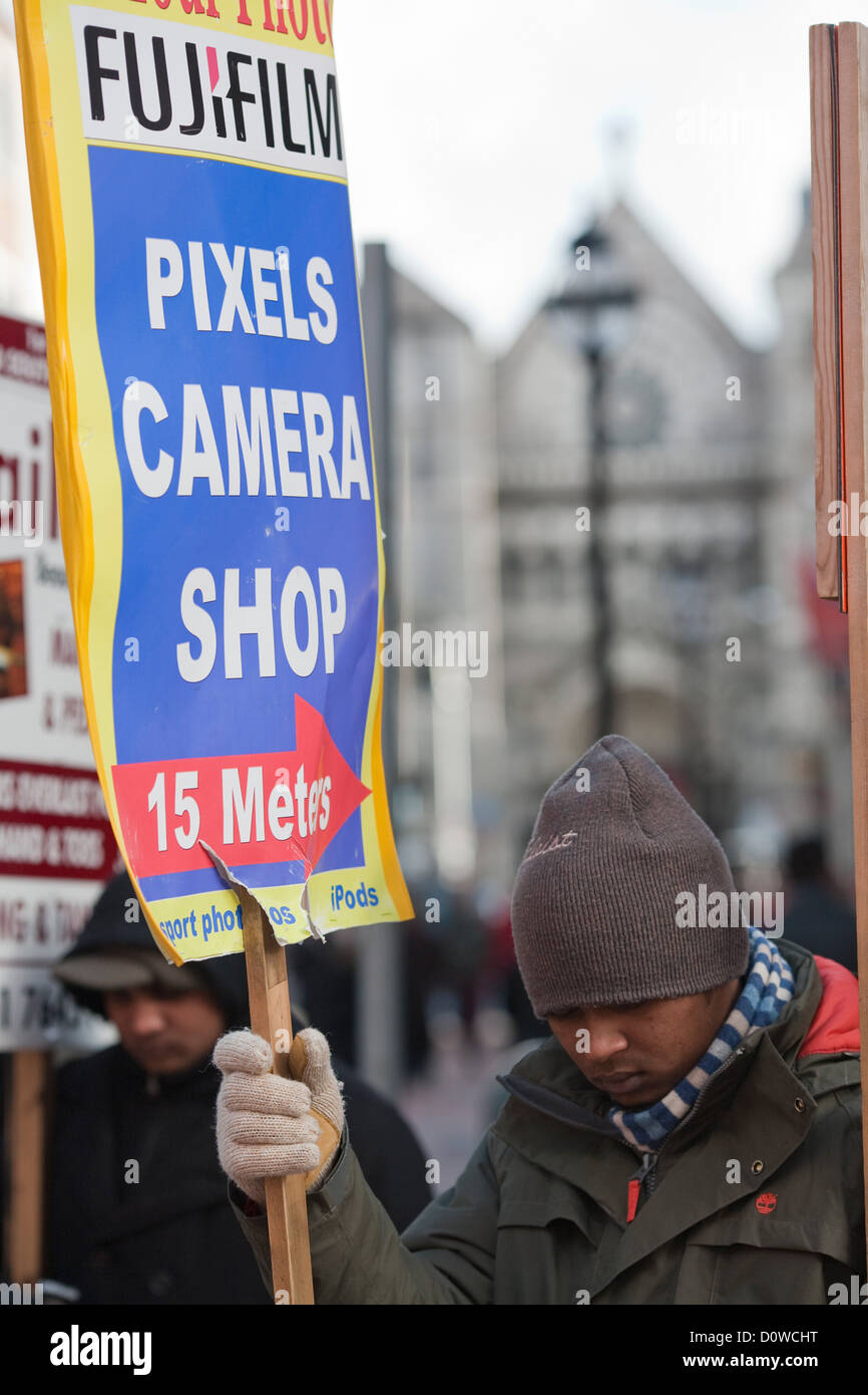 Dublin, Irland, Mann mit einem Werbeplakat für eine Foto-shop Stockfoto
