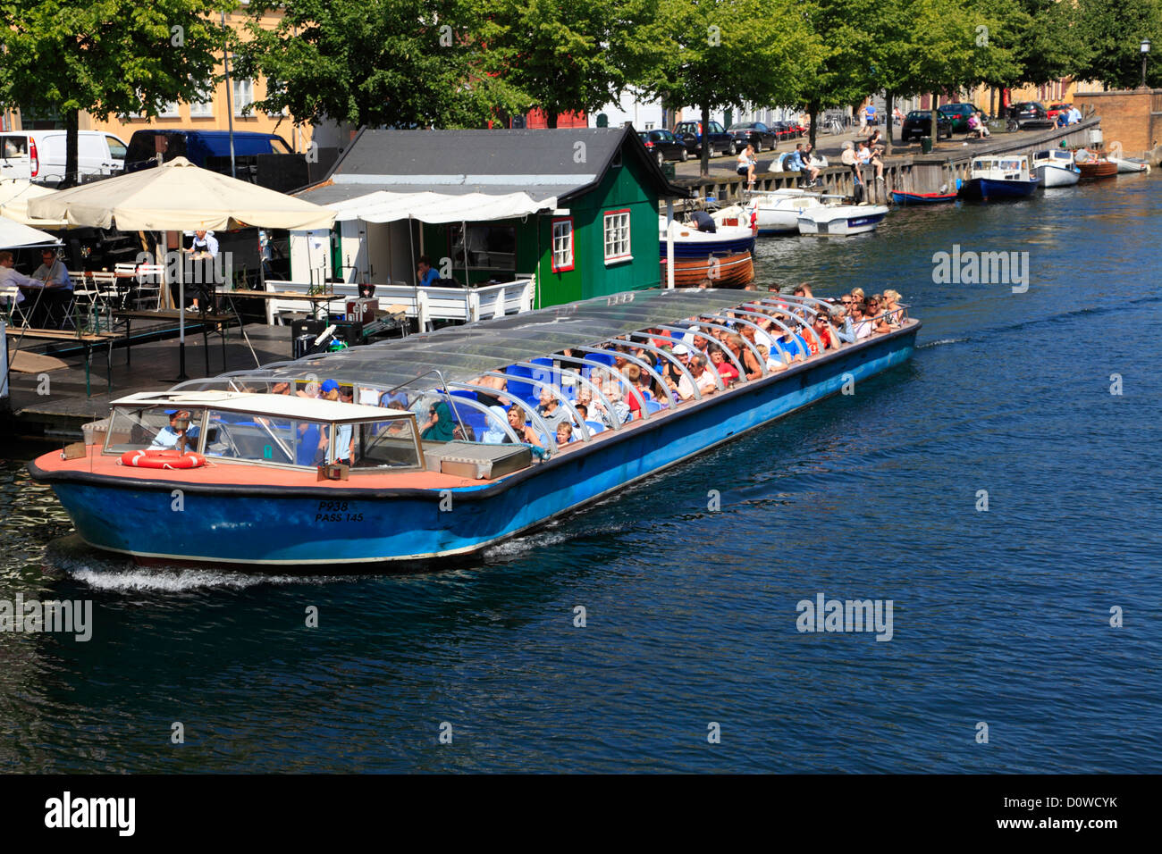 Canal cruise Boot in den alten und gemütlichen Christianshavns Kanal in Kopenhagen, Dänemark, mit Restaurants und Cafés entlang der Ufer. Stockfoto
