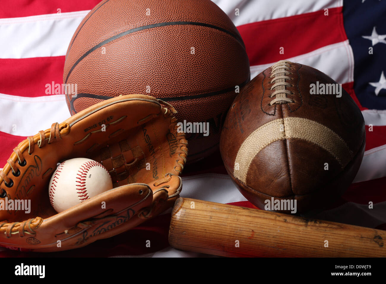 Eine Studioaufnahme ein American Football, ein Basketball und Baseball Ball, Mitt und Fledermaus. Stockfoto