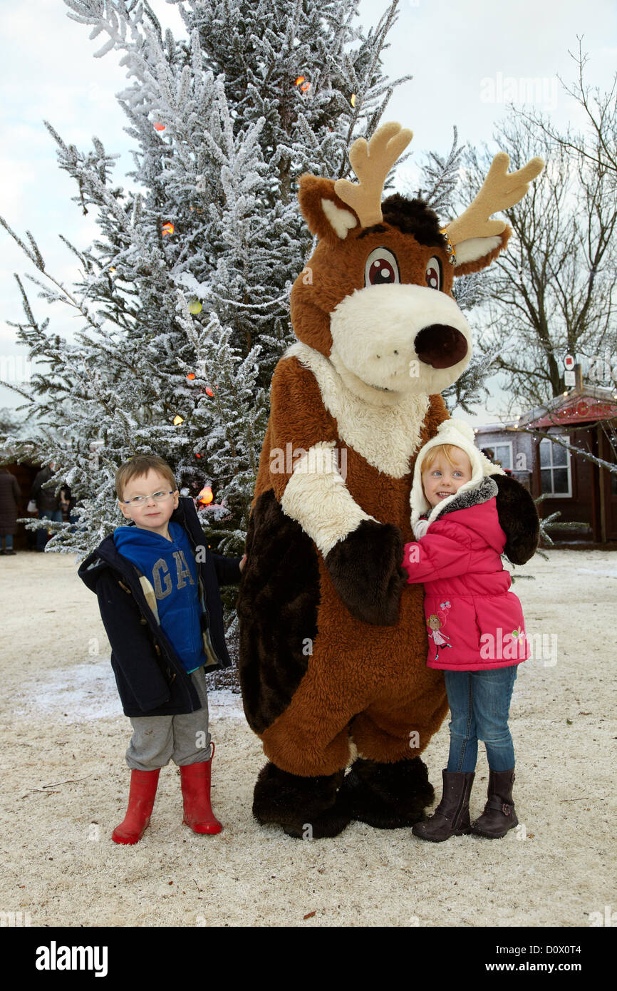 Kinder treffen im Elf-Dorf auf Rentierfiguren. Lappland, Großbritannien, Bewl Water, Kent, 1. Dezember 2012. Stockfoto