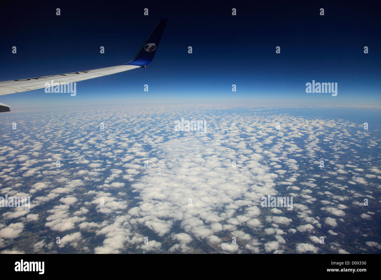 Blick aus dem Flugzeug Fenster TS Airlines Logo und Flügel, Golf von Biskaya, Französisch Küste mit Altocumulus Stratiformis Wolken. Stockfoto
