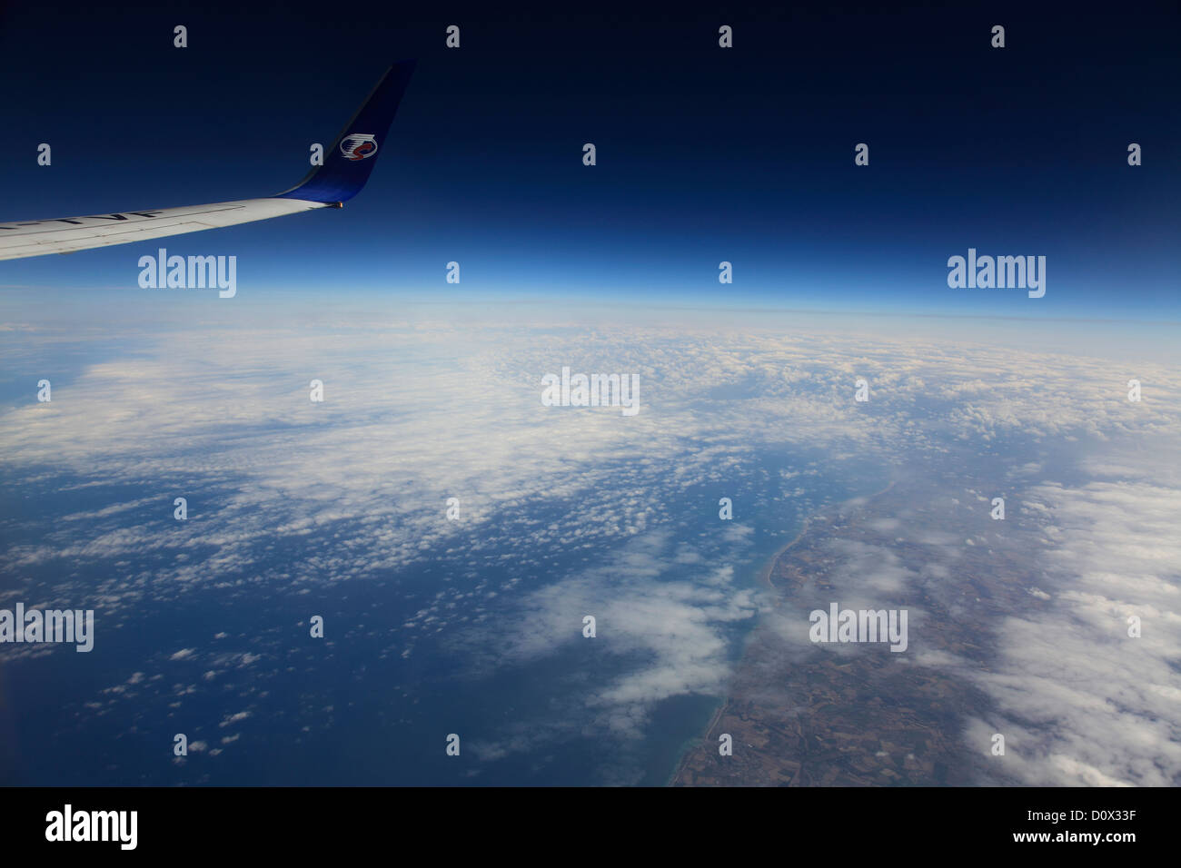Blick aus dem Flugzeug Fenster TS Airlines Logo und Flügel, Golf von Biskaya, Französisch Küste mit Altocumulus Stratiformis Wolken. Stockfoto