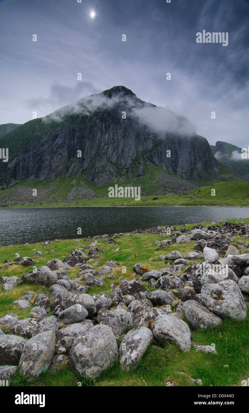 Felsen am Ufer eines Sees am Fuße der Bergkette in der Nähe von Eggum, Lofoten, Norwegen Stockfoto