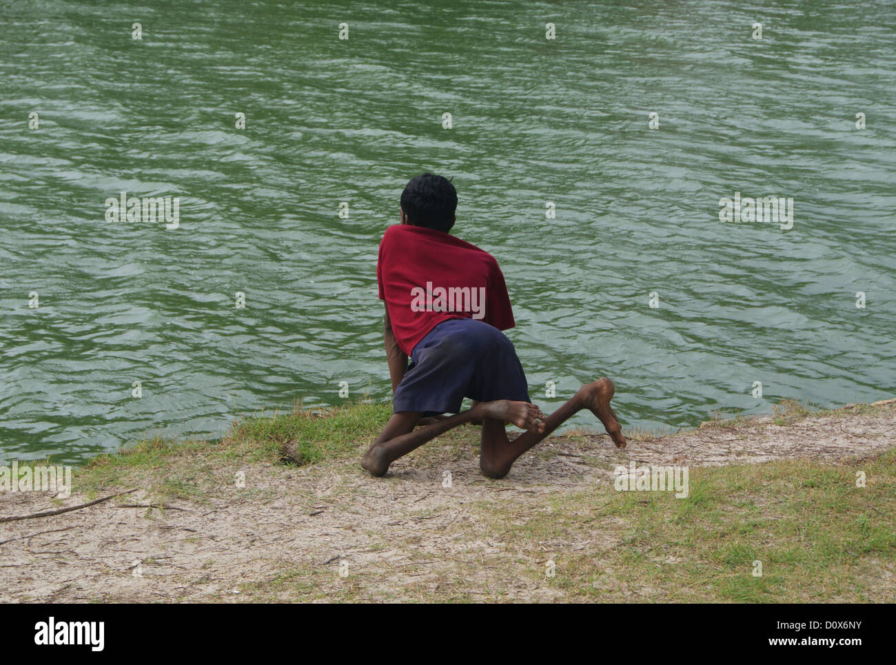 Behinderten Mann auf der Suche in den Backwaters von Kerala vom Ufer des ländlichen Dorf in Indien Stockfoto