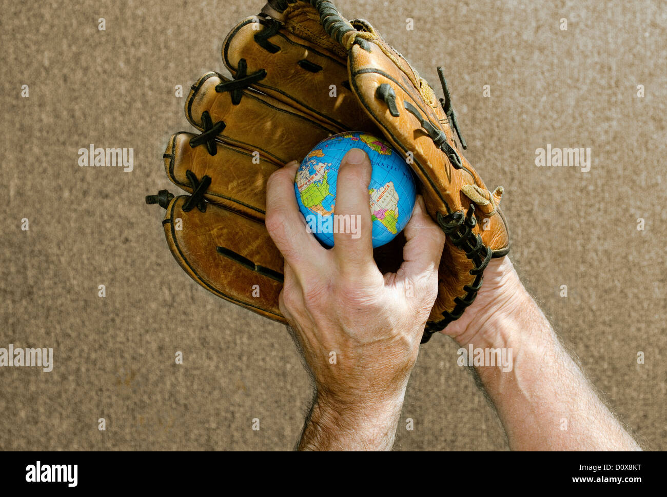 Globus in Baseballhandschuh hält Baseballspieler Stockfoto