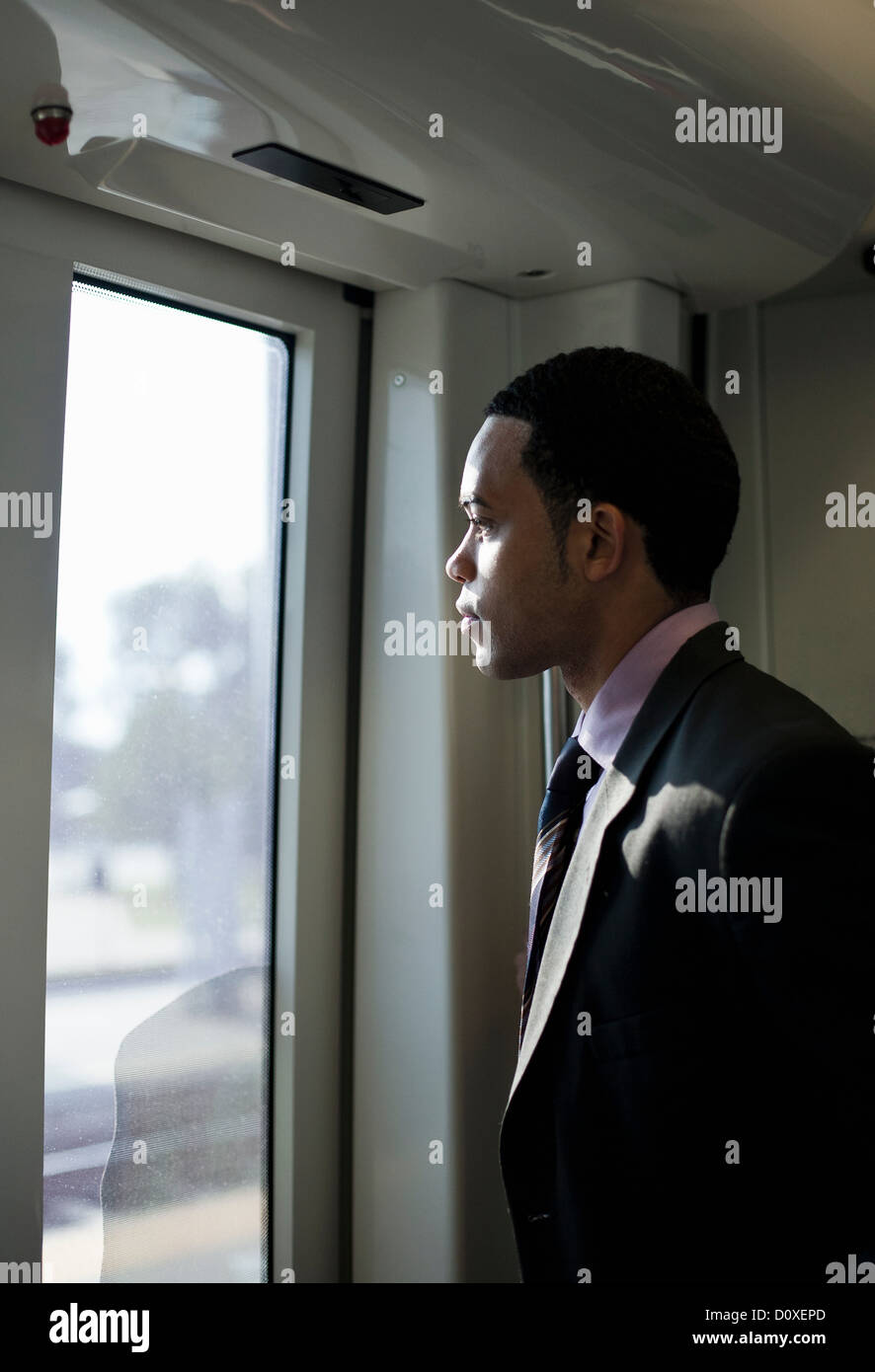 Geschäftsmann in einem Zug Blick durch Fenster Stockfoto