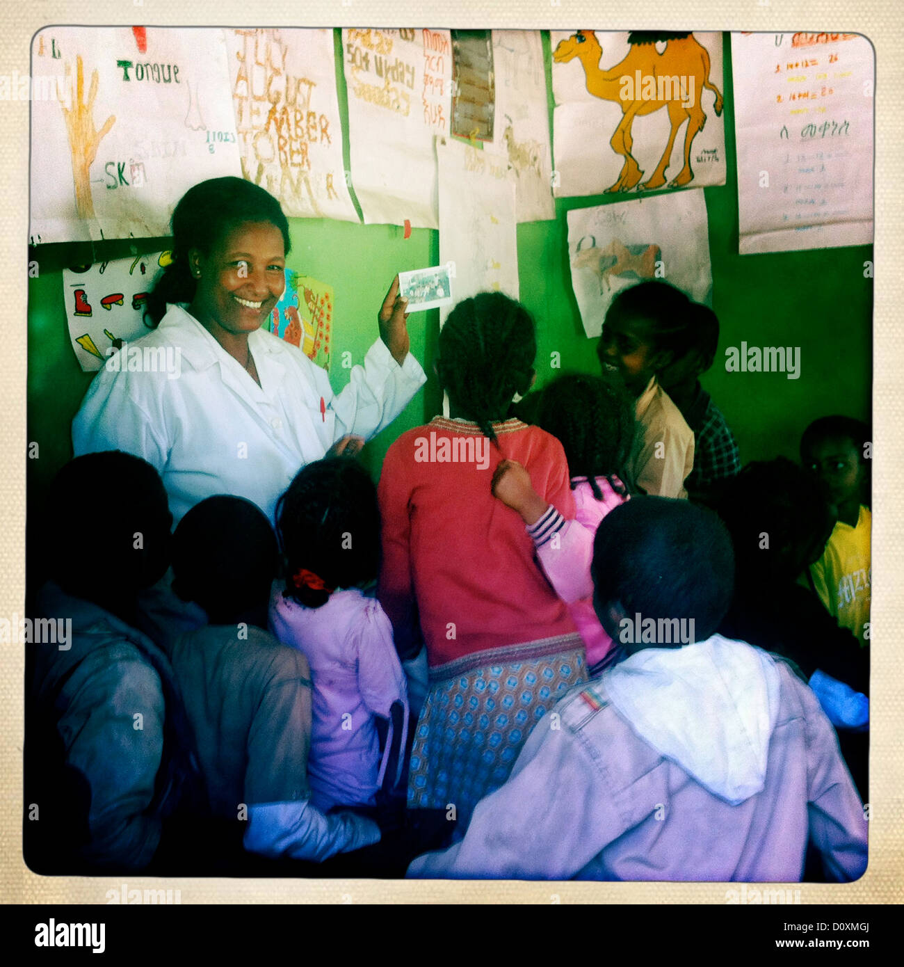 Lehrer mit Toothy Lächeln zeigt Rasta Kinder ein Bild In Shashemene Jamaican School, Oromia Region, Äthiopien Stockfoto