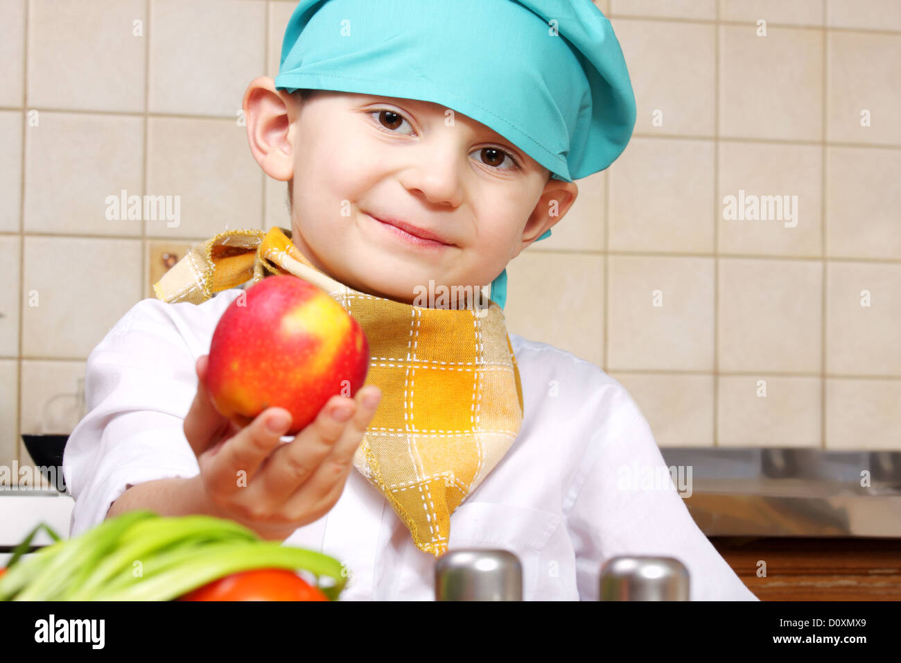 Kleine Köchin junge geben roten Apfel Stockfoto