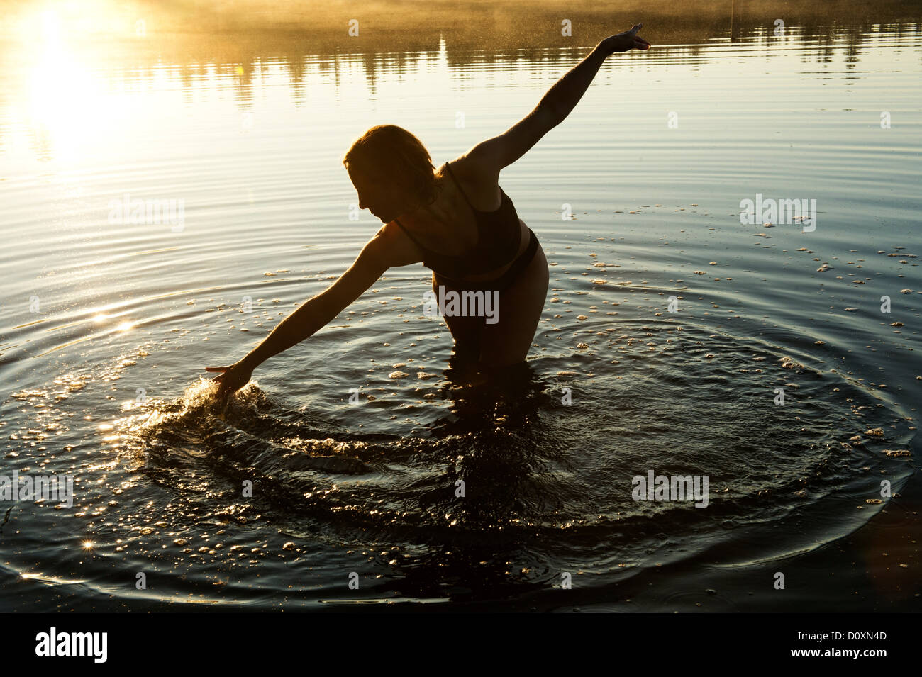 Frau berühren Wasser im See Stockfoto