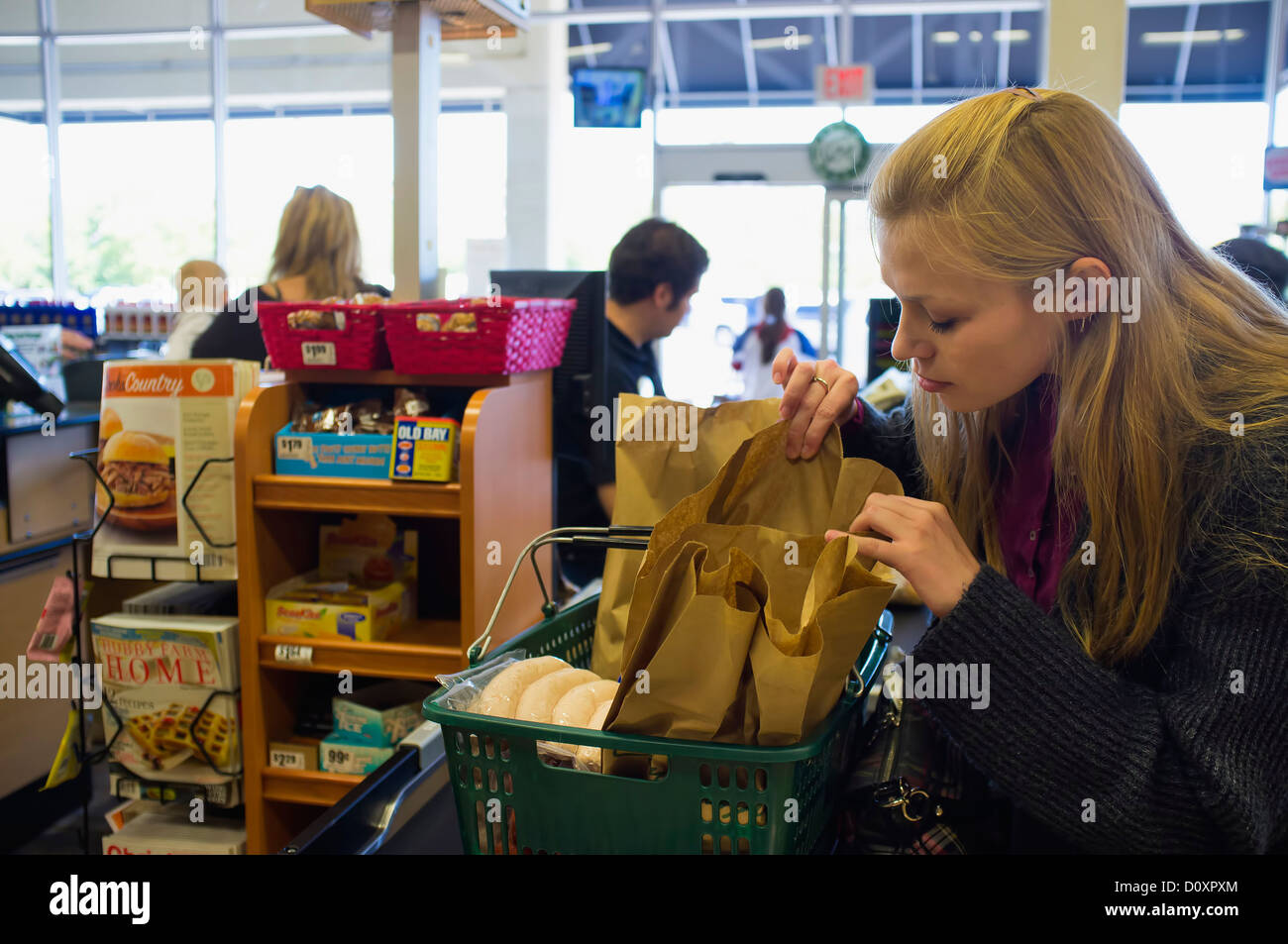 Junge Frau an der Kasse im amerikanischen Supermarkt Auschecken Stockfoto