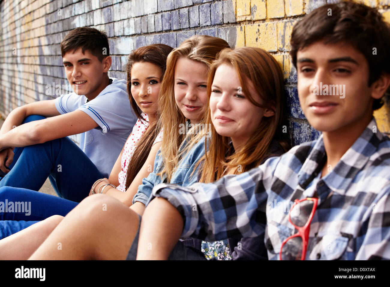 Jugendliche sitzen in einer Reihe Stockfoto