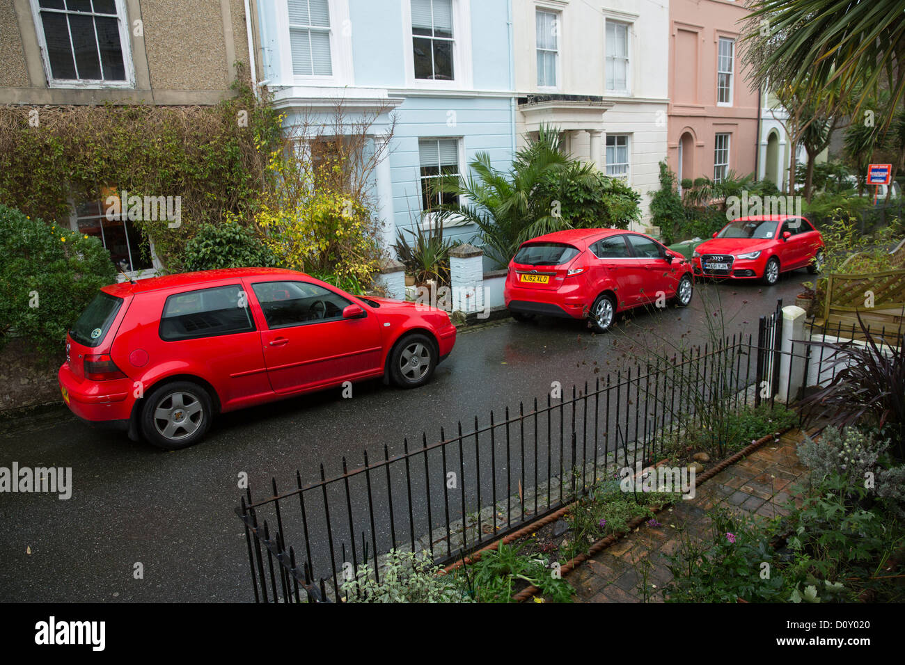 Drei rote Autos erhellen diese georgische Straße an einem langweiligen Tag L-R Volkswagen Ford Audi Stockfoto