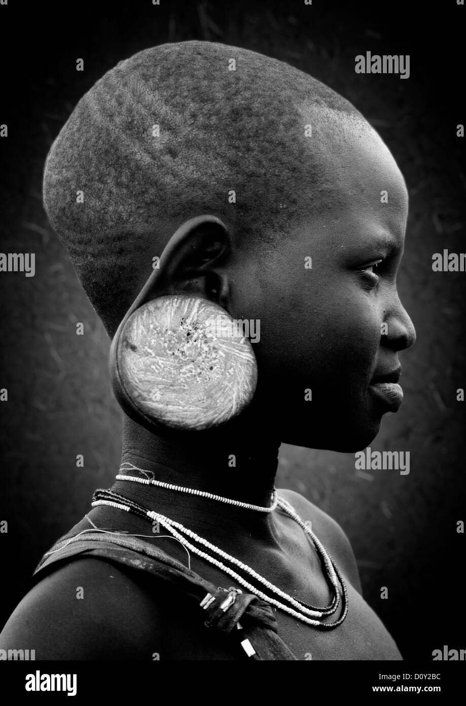 Schwarz / weiß Profil Portrait eines jungen Mädchens der Mursi Stamm mit erweiterten Ohr Ohr Platte, Omo-Tal, Äthiopien Stockfoto
