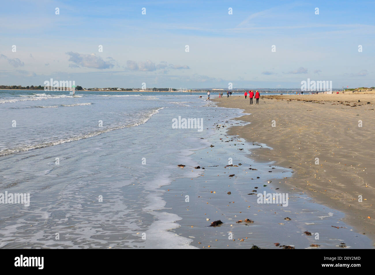 Szene von Menschen Flanieren entlang der Vorland West Wittering Beach, nr Chichester, West Sussex.Hayling Insel in der Ferne Stockfoto