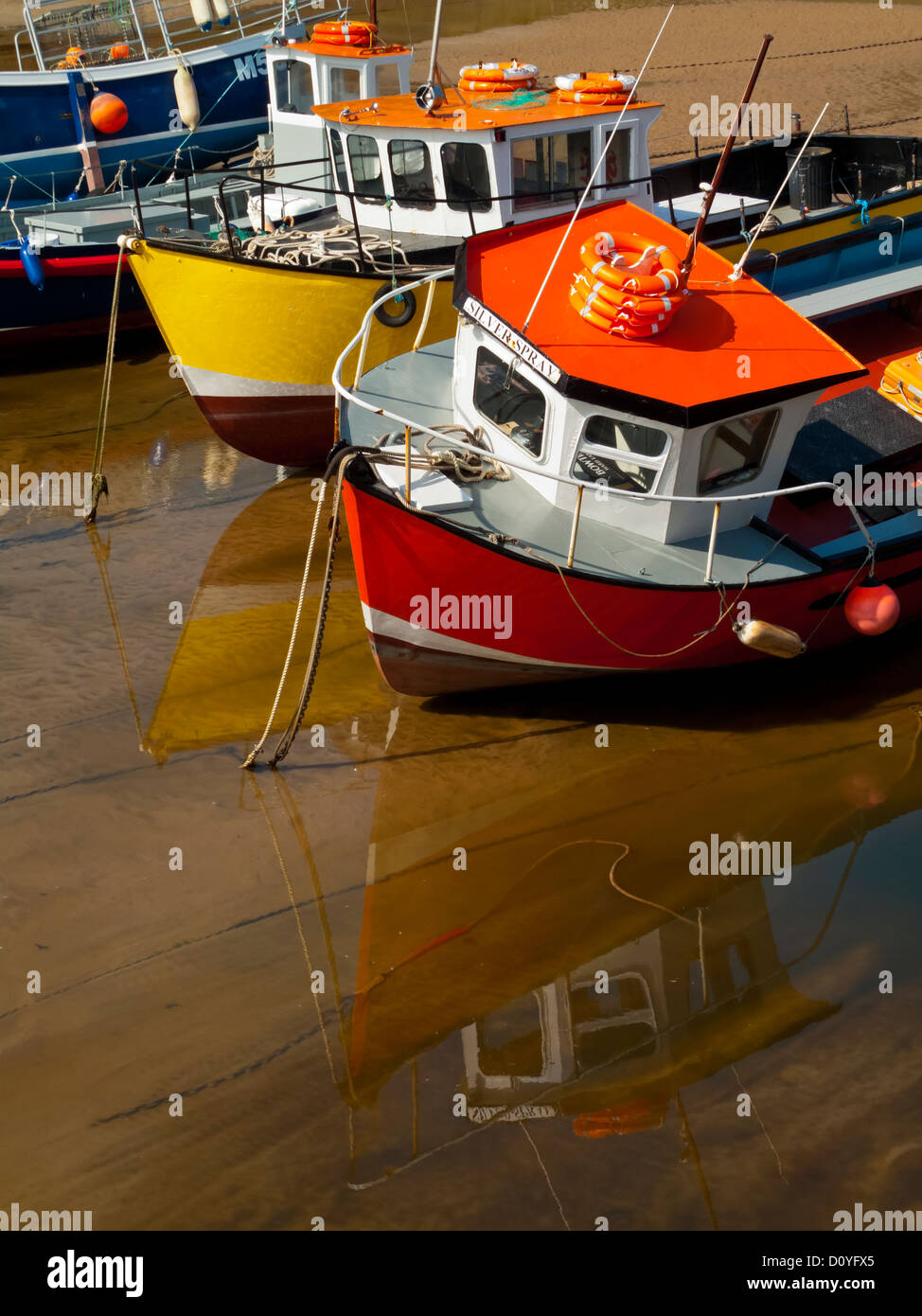 Kleine Boote auf dem Sand bei Ebbe im Hafen von Tenby Pembrokeshire South Wales UK Stockfoto