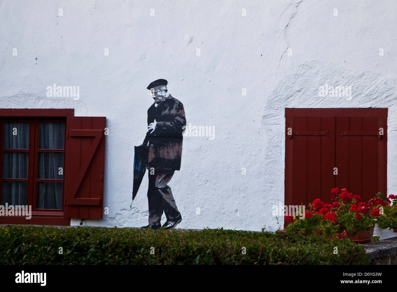 Wandbild im spanischen Dorf Burguete (Auritz) eines Gentleman bei einem Spaziergang mit seinem Regenschirm Kunst im öffentlichen Raum in Spanien Stockfoto