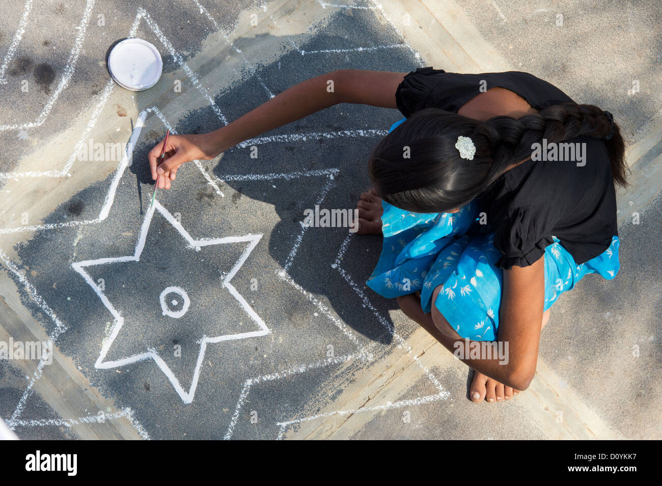 Teenager Indianerdorf Mädchen malen ein Rangoli Design vor ihrem Haus. Andhra Pradesh, Indien Stockfoto