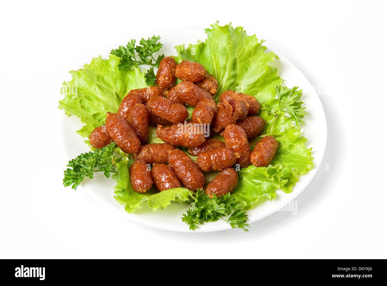 gegrillte Würstchen auf grünem Salat Stockfoto