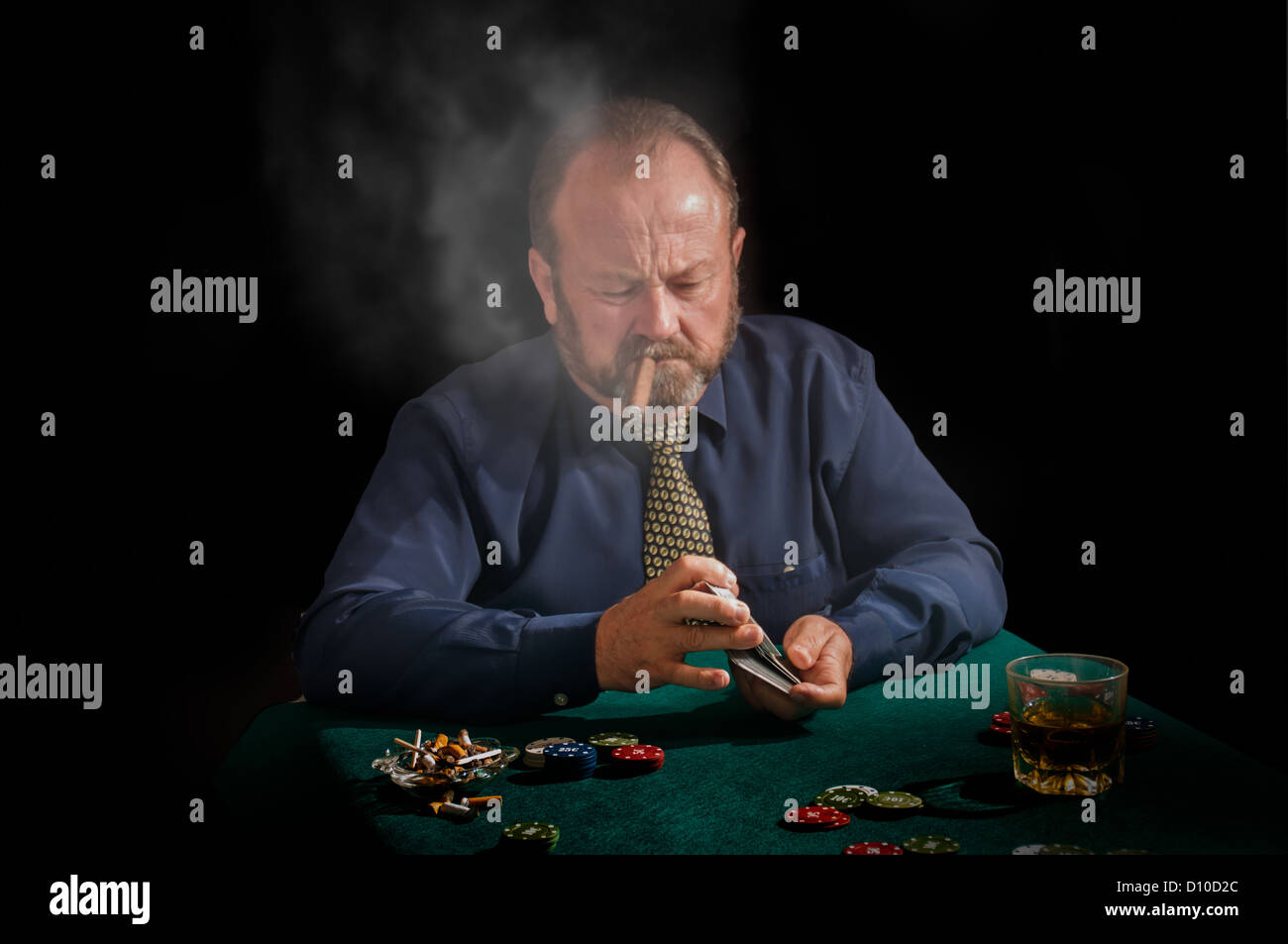 Eine Zigarre rauchen Reifen männlichen mischt seine Karten Stockfoto