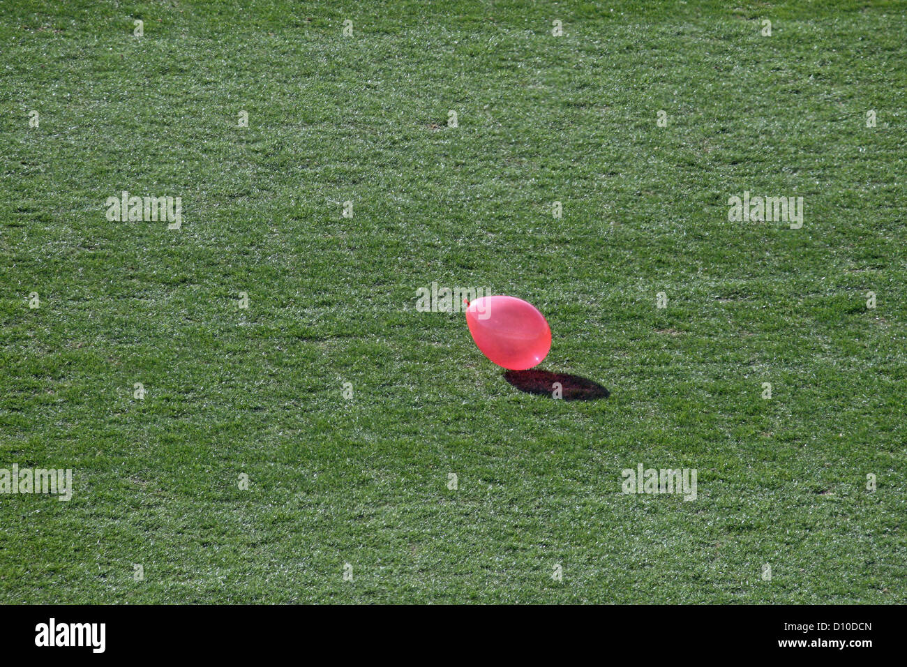 Rosa Ballons fliegen über dem grünen Rasen des Stadions Stockfoto