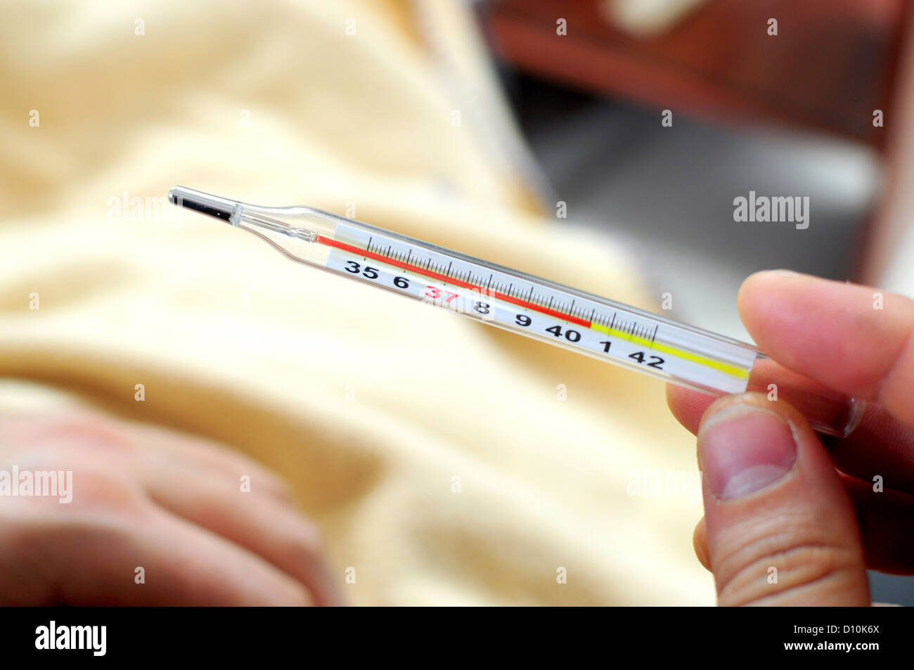 Hand mit Thermometer zeigt hohe Temperatur Stockfoto