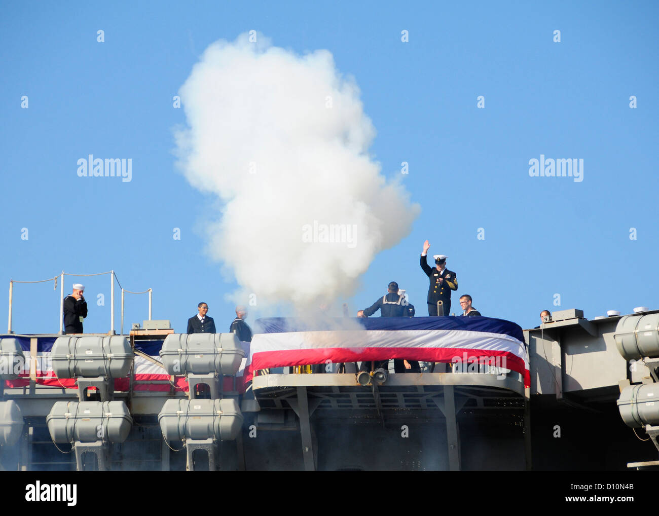 Seeleute an Bord der USS Enterprise (CVN 65) feuern die Kanone des Schiffes ab, um den Chief of Naval Operations Admiral Jonathan W. Greenert während der Inaktivierungszeremonie des ersten nuklearbetriebenen Flugzeugträgers USS Enterprise zu ehren. Stockfoto