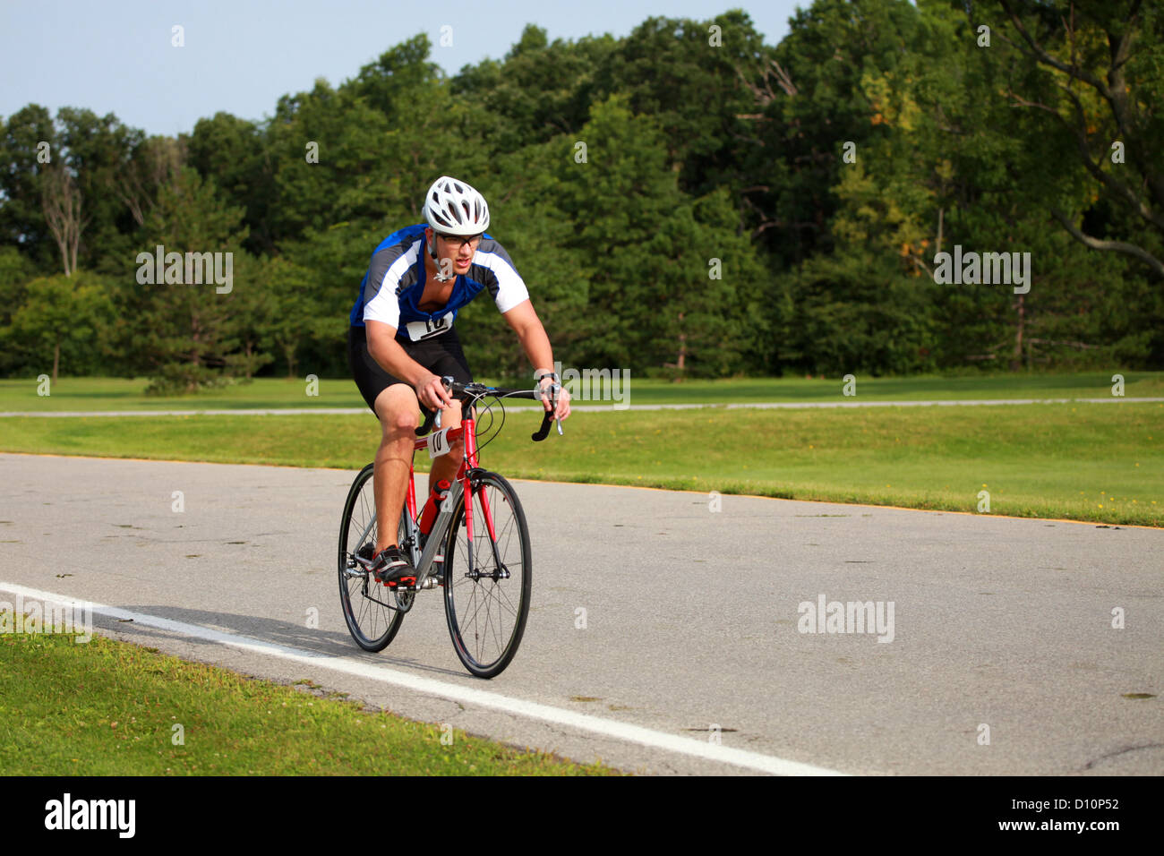 Radfahren auf einer Parkstraße bei einem Triathlon Sportler. Stockfoto