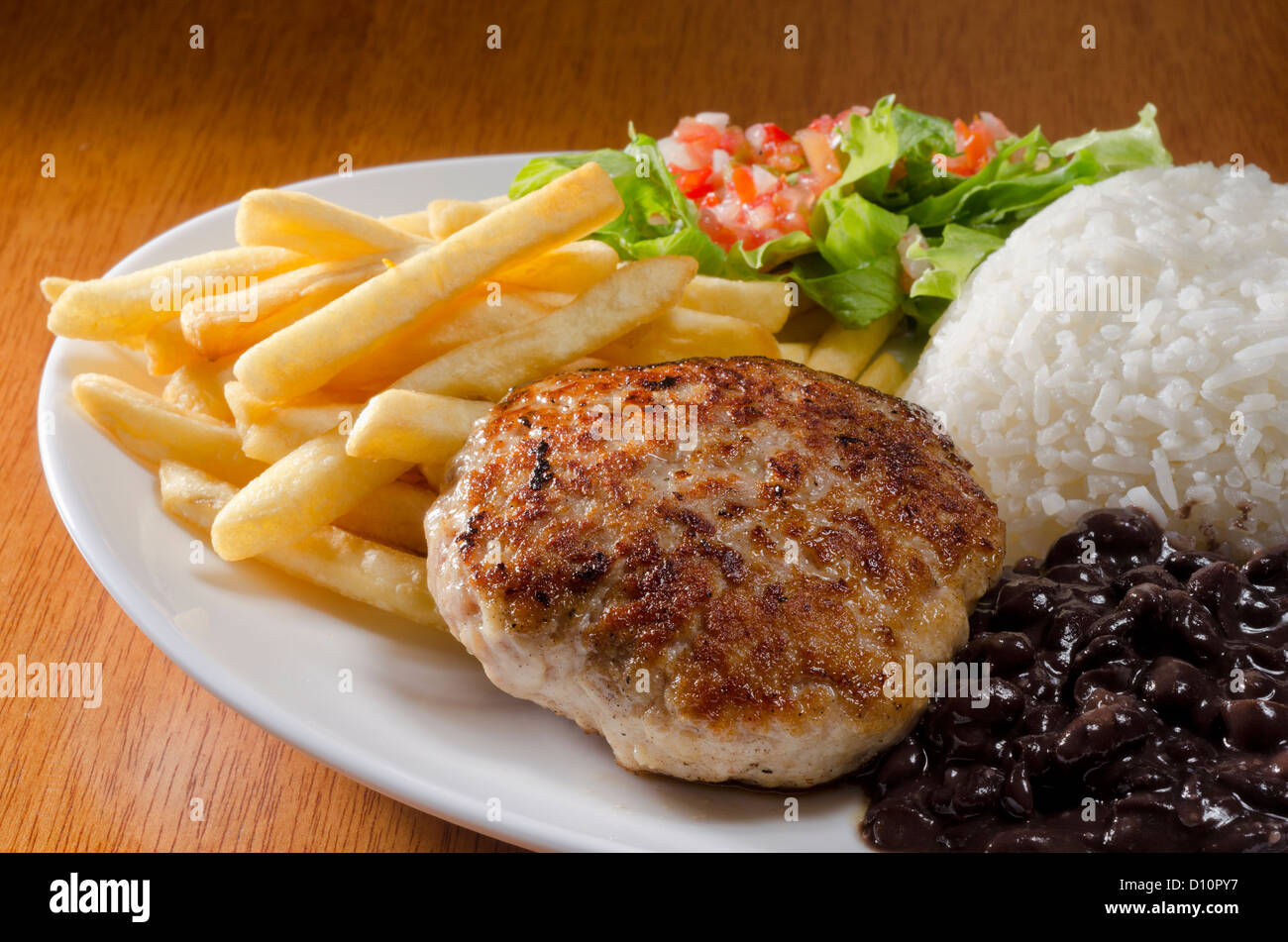 Burger mit Salat, Pommes frites, Reis und Bohnen Stockfoto