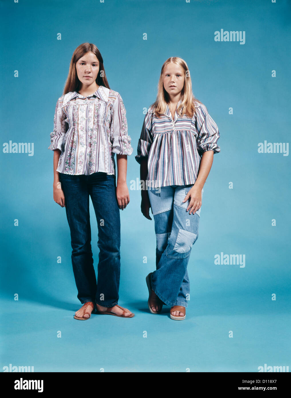 1970ER JAHRE BLUSEN PORTRAIT ZWEI TEEN GIRLS STEHEN VOLL LÄNGE TRAGEN DENIM BLUE JEANS BAUER SANDALEN Stockfoto