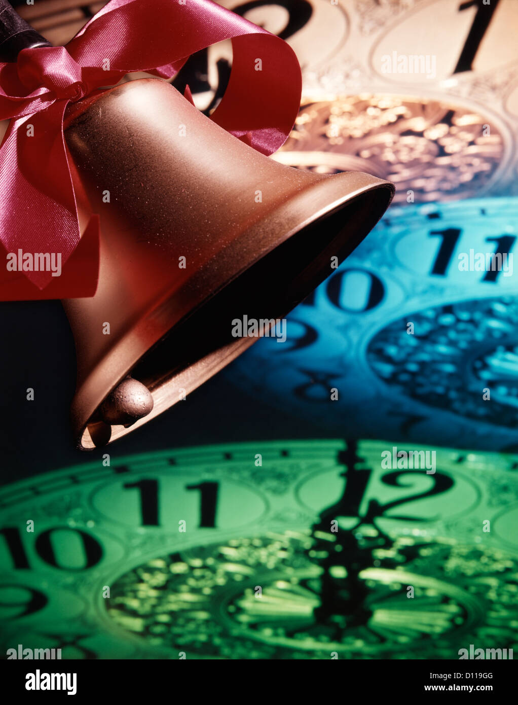 1960ER JAHRE GOLDENE GLOCKE MIT ROTEN BOGEN KLINGELN IM NEUEN JAHR VOR HINTERGRUND DER ZIFFERNBLATT ZEIGT MITTERNACHT Stockfoto